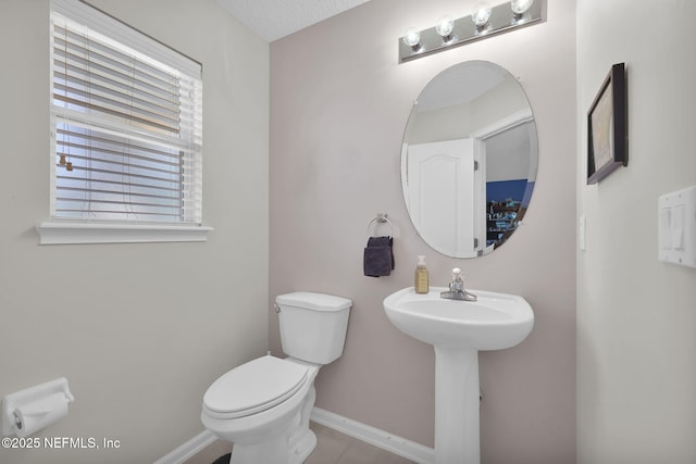 bathroom featuring tile patterned floors, toilet, and baseboards