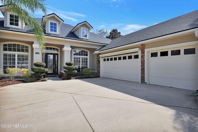 view of front of property with a garage, concrete driveway, roof with shingles, and stucco siding