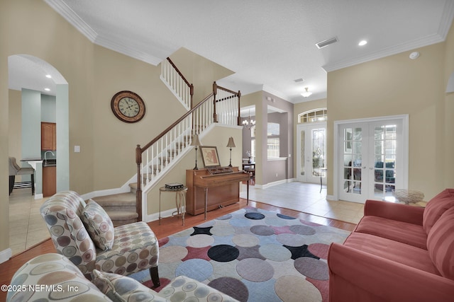 living room with crown molding, visible vents, and plenty of natural light