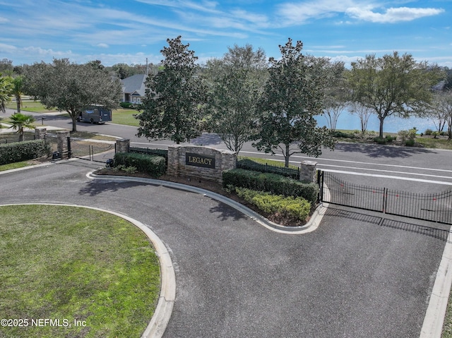 view of road with a gate, curbs, and a gated entry