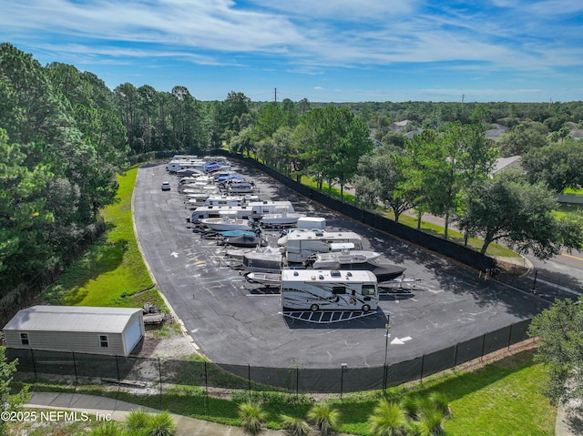 view of property's community with fence and a view of trees