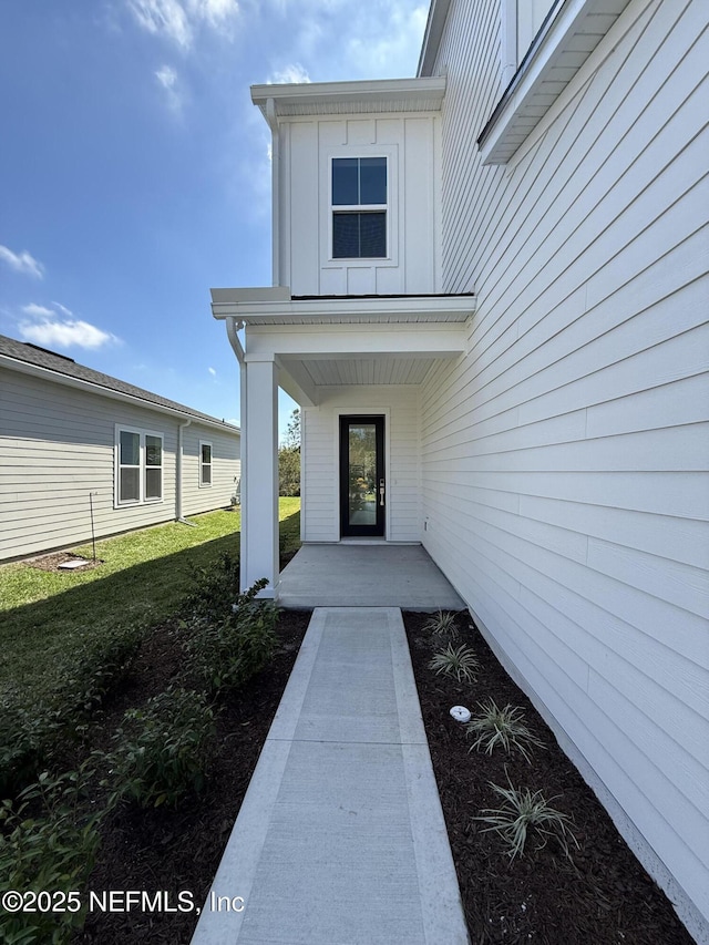 35 Mahogany Way, Palm Coast, FL 32164 - view of exterior entry featuring covered porch and a lawn