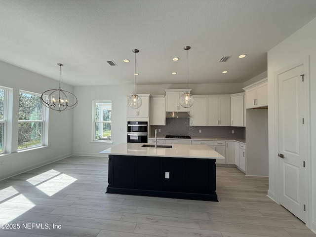 35 Mahogany Way, Palm Coast, FL 32164 - kitchen featuring white cabinetry, decorative backsplash, and an island with sink
