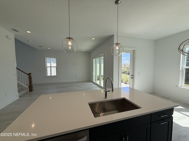 35 Mahogany Way, Palm Coast, FL 32164 - kitchen with sink, decorative light fixtures, an island with sink, and light wood-type flooring