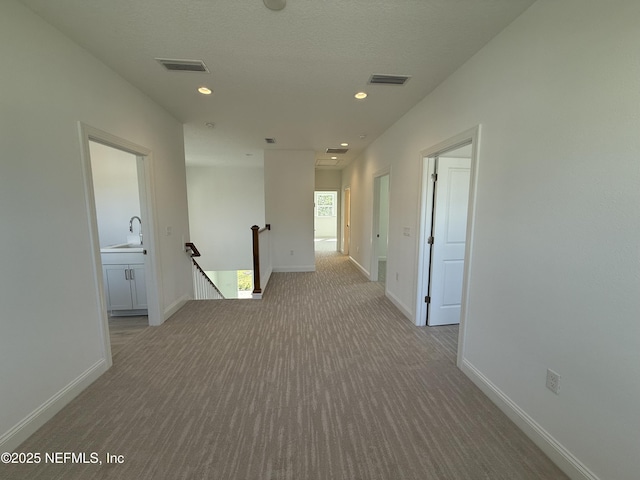 35 Mahogany Way, Palm Coast, FL 32164 - hall with sink, light colored carpet, and a textured ceiling