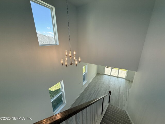 35 Mahogany Way, Palm Coast, FL 32164 - staircase with a notable chandelier, hardwood / wood-style floors, and a high ceiling