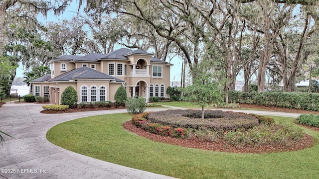 view of front of home featuring a front yard and a balcony