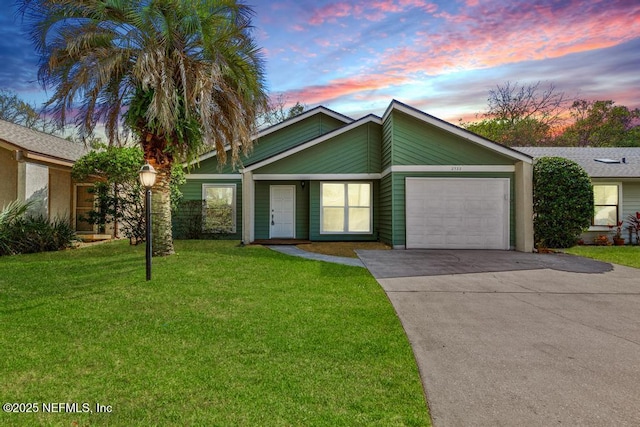 mid-century home featuring a garage, a front yard, and concrete driveway