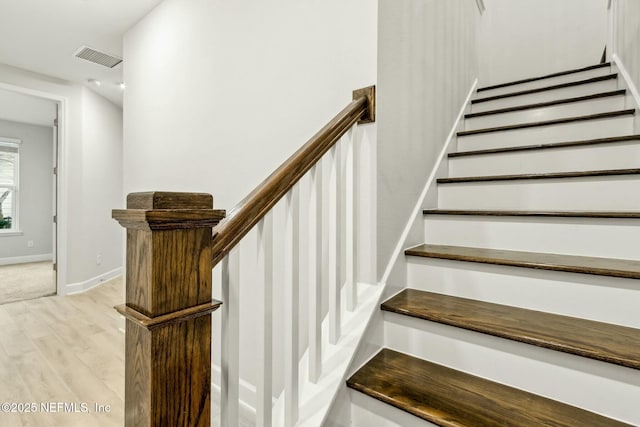 stairs featuring baseboards, visible vents, and wood finished floors