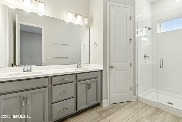 bathroom with double vanity, a stall shower, and a sink