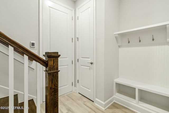 mudroom featuring light wood finished floors and baseboards