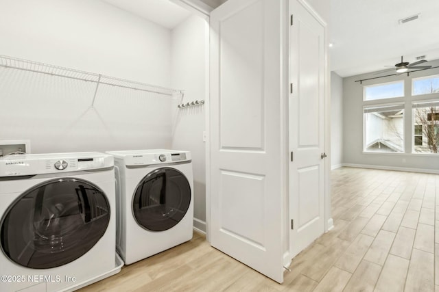 laundry area featuring visible vents, light wood-style floors, a ceiling fan, washer and dryer, and laundry area