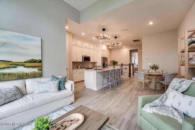 11484 Gully Ct, Jacksonville, FL 32256 - living room featuring light wood-style flooring, a chandelier, and recessed lighting
