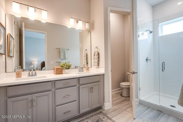 11484 Gully Ct, Jacksonville, FL 32256 - ensuite bathroom featuring double vanity, a stall shower, toilet, and baseboards