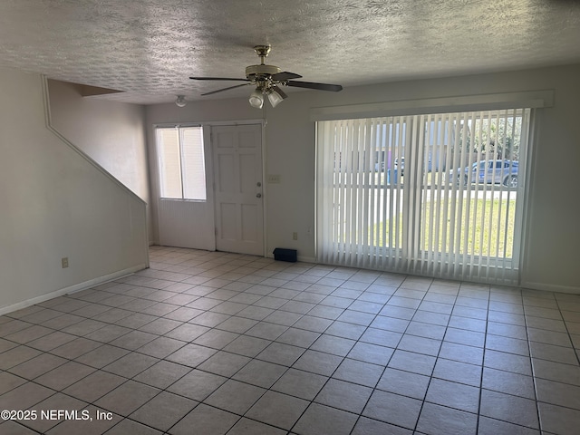 tiled foyer entrance with ceiling fan and a textured ceiling