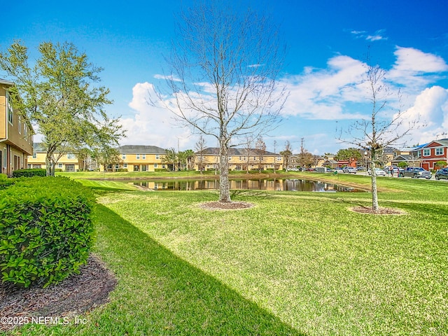 view of yard featuring a residential view and a water view