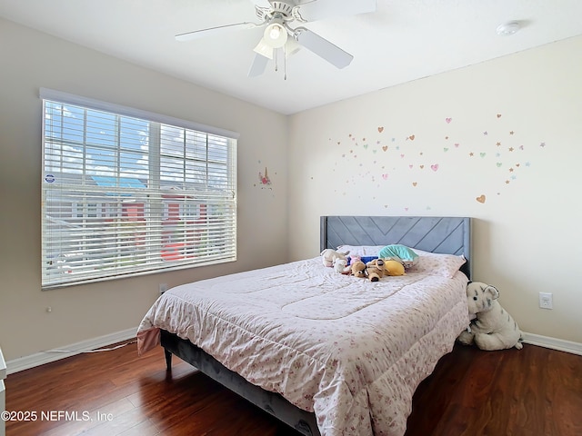 bedroom featuring wood finished floors, a ceiling fan, and baseboards