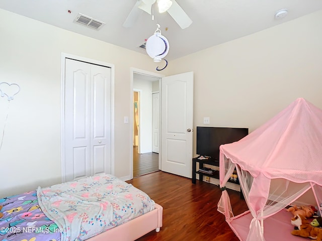 bedroom with dark wood-style floors, a closet, visible vents, and ceiling fan