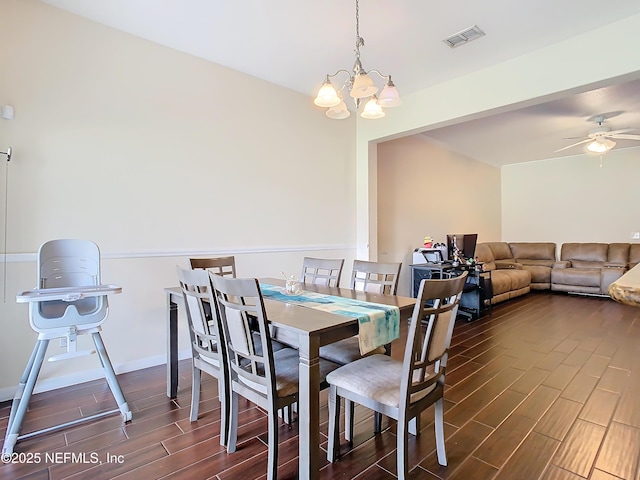 dining room with ceiling fan with notable chandelier, baseboards, visible vents, and wood tiled floor