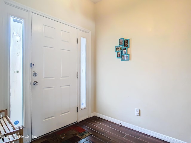 entrance foyer with dark wood-style floors and baseboards