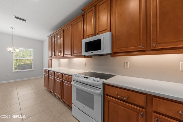 kitchen featuring white appliances, visible vents, light countertops, brown cabinets, and glass insert cabinets