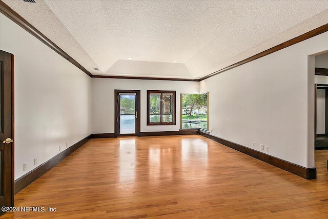 13612 Mcqueens Ct, Jacksonville, FL 32225 - empty room featuring a raised ceiling, light hardwood / wood-style floors, and a textured ceiling