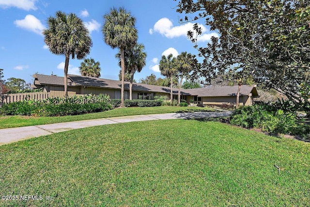 ranch-style house featuring fence, a front lawn, and concrete driveway