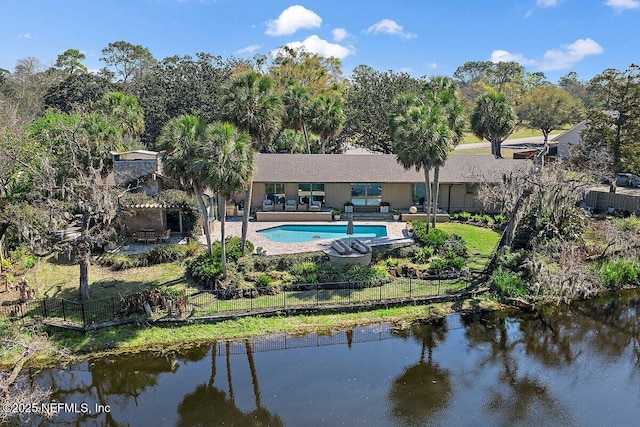 rear view of property with a water view, fence, a fenced in pool, and a patio