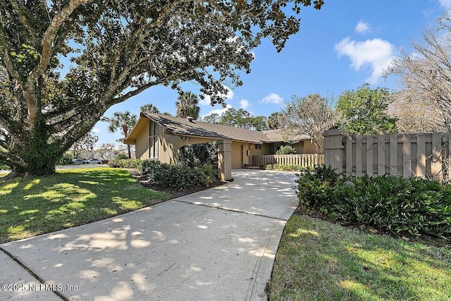 view of front of home featuring fence and a front lawn