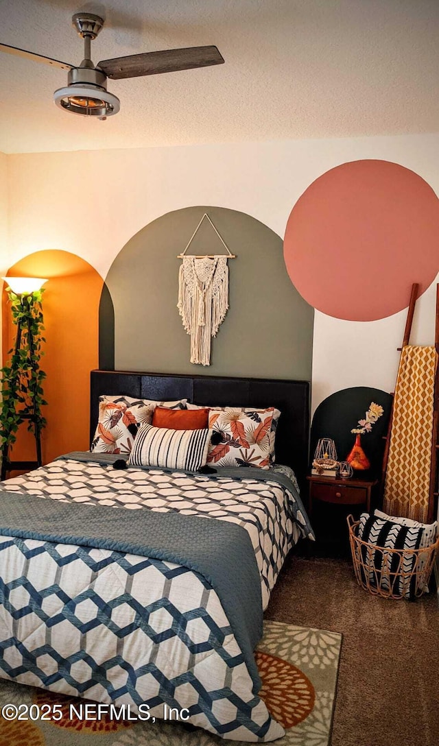 bedroom with ceiling fan, a textured ceiling, and carpet