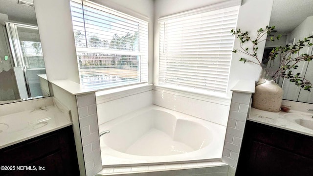 bathroom featuring vanity and tiled tub