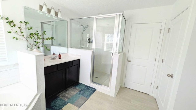 bathroom with vanity, an enclosed shower, and a textured ceiling