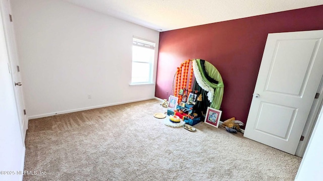 rec room featuring light carpet and a textured ceiling