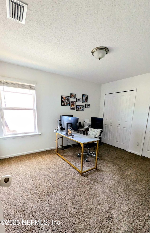 carpeted home office with a textured ceiling