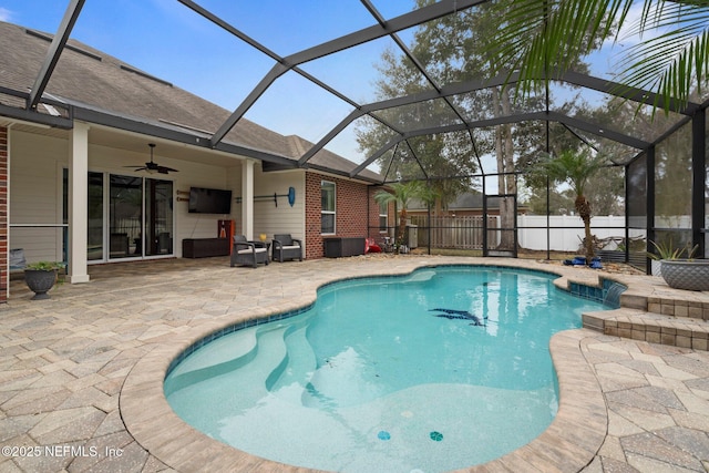 view of swimming pool featuring a patio, glass enclosure, and ceiling fan