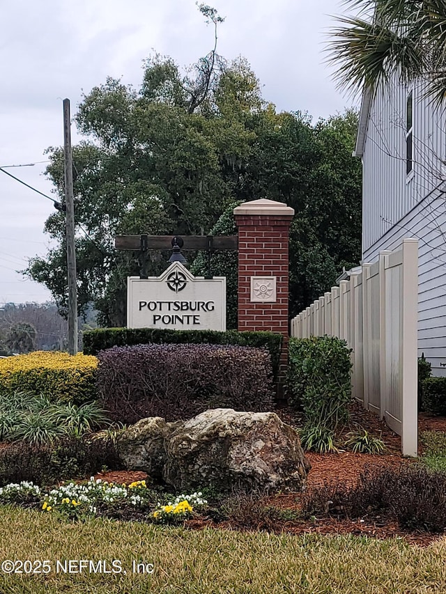 community / neighborhood sign with fence