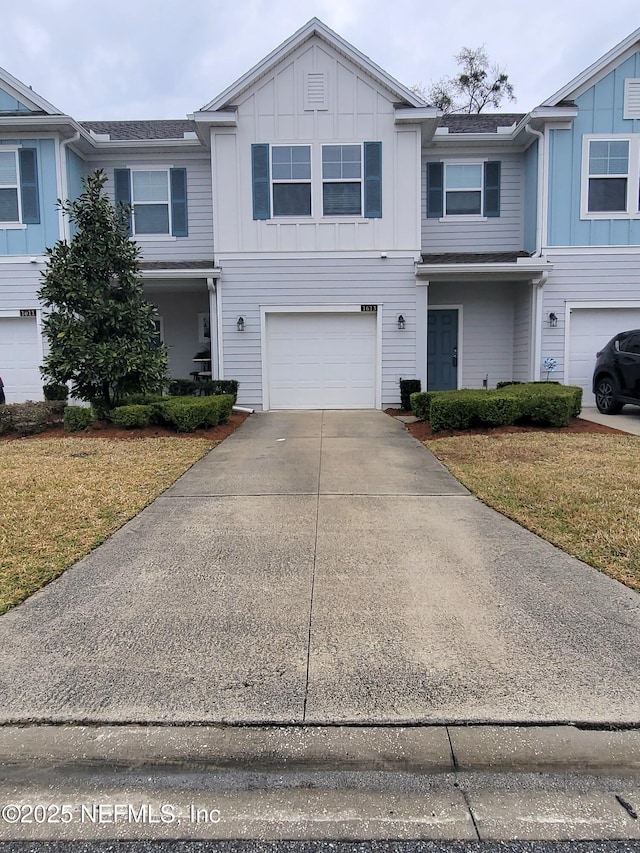 townhome / multi-family property with a garage, driveway, a front lawn, and board and batten siding