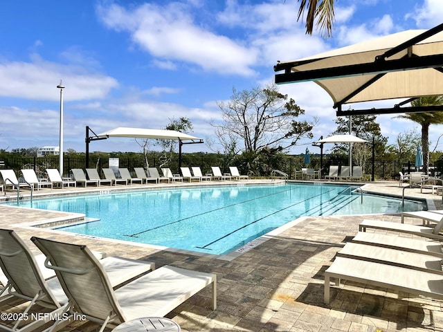 pool with a patio and fence