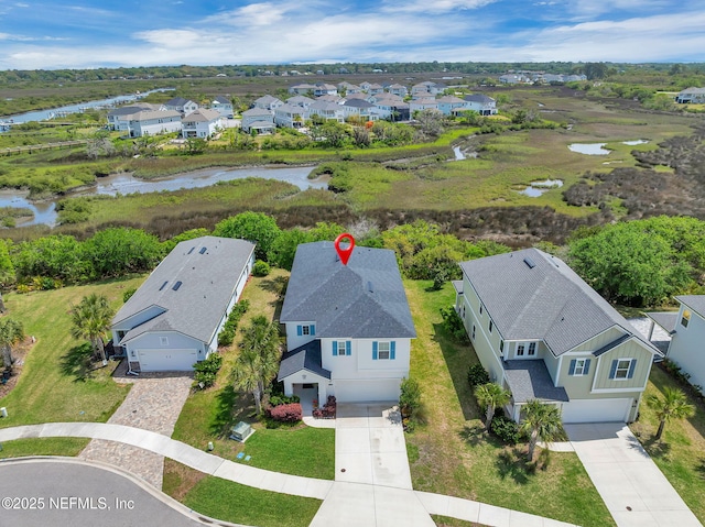 drone / aerial view featuring a water view and a residential view