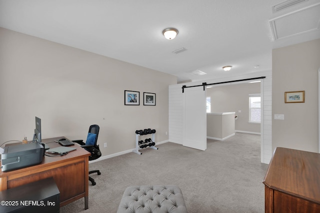 home office with visible vents, baseboards, carpet flooring, and a barn door