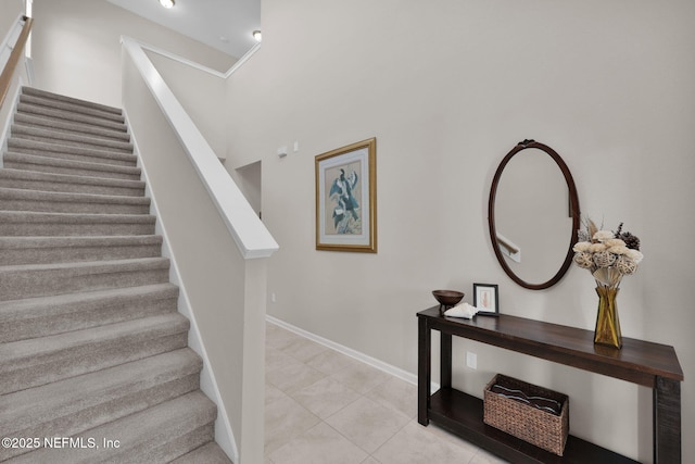 staircase with baseboards and tile patterned flooring