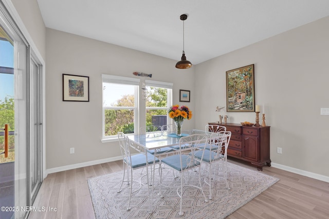dining area with light wood-style flooring and baseboards