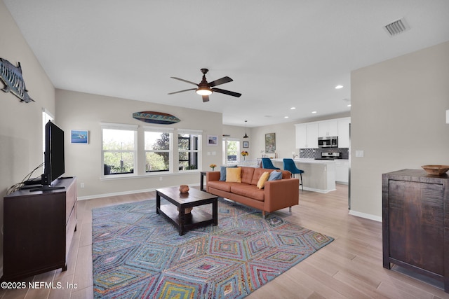 living area with recessed lighting, visible vents, light wood-type flooring, and ceiling fan