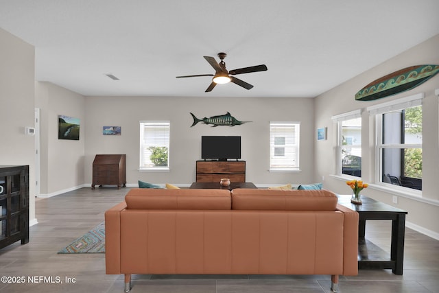 living area with wood finished floors, ceiling fan, and a wealth of natural light