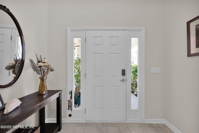 entrance foyer featuring light tile patterned floors, a wealth of natural light, and baseboards