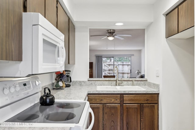 kitchen with white appliances, ceiling fan, and sink