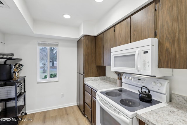 kitchen with white appliances and light hardwood / wood-style floors