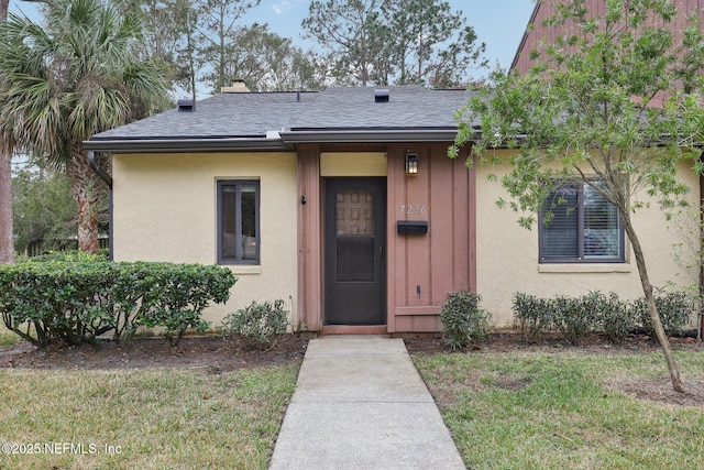 doorway to property with a lawn