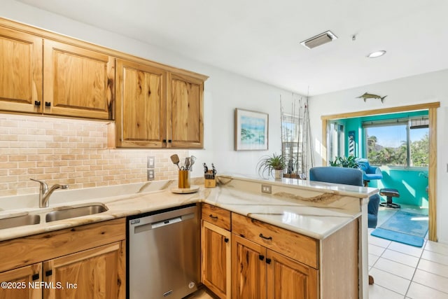 kitchen featuring light tile patterned floors, a peninsula, a sink, stainless steel dishwasher, and tasteful backsplash