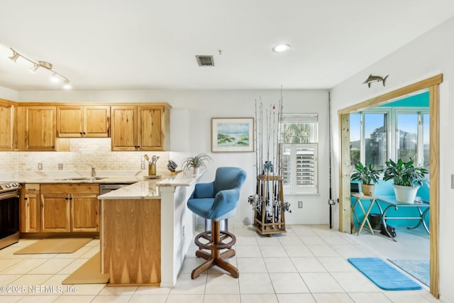 kitchen featuring a sink, visible vents, backsplash, and a peninsula